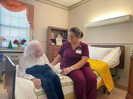 Caregiver providing compassionate end-of-life support to a resident at Scottish Pines in Laurinburg, NC