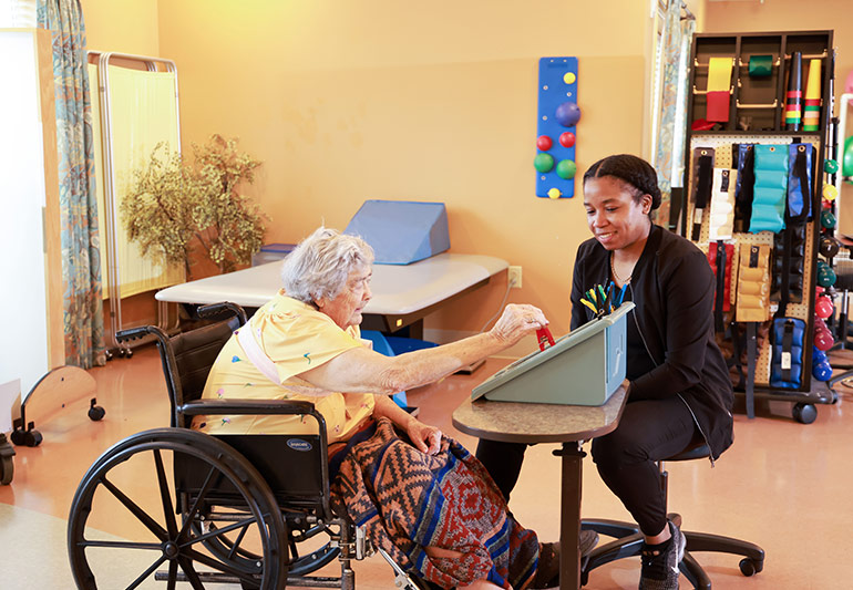 Care team member reviewing discharge and care transition goals with a resident